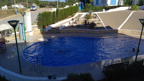 een groot zwembad met blauw water op een parkeerplaats bij Résidence lilia jabal mdiq in M'diq