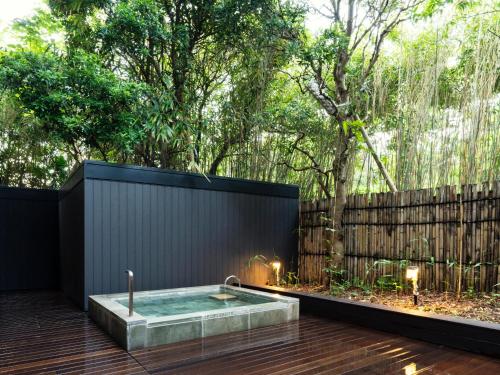 a hot tub in a backyard with a fence at Numazu Club in Numazu