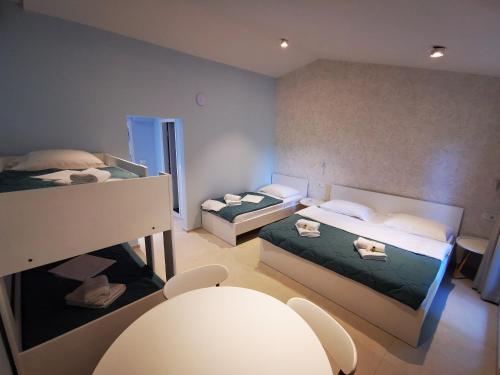 Habitación pequeña con 2 camas y mesa. en Morski gaj Resort, en Piran
