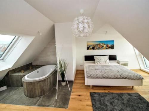 - une chambre mansardée avec un lit et une baignoire dans l'établissement Luxury 2-floor Rooftop Apartment with terrace in the city center, à Vienne