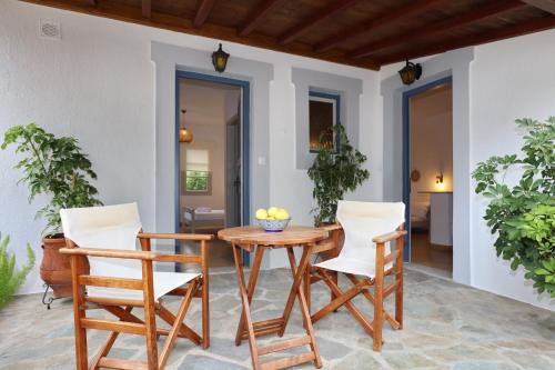 a patio with a wooden table and two chairs at Skopelos Panos Studios in Stafylos