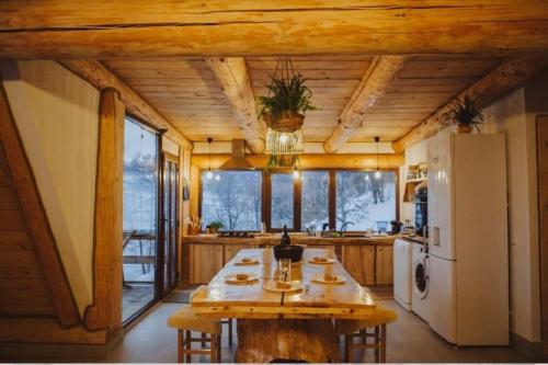 uma grande cozinha com uma mesa e um frigorífico em Aframehouse em Şurdeşti