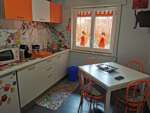 a kitchen with a table and chairs and two windows at Mq 36 in Marsala