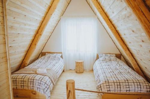 two beds in the attic of a wooden house at Aframehouse in Şurdeşti