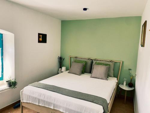 een slaapkamer met een groot bed met groene muren bij Family-sized renovated Istrian house w/lavand field - 20min from Rovinj. in Žminj