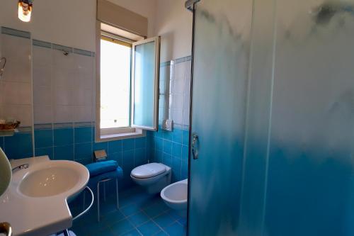 a blue bathroom with a toilet and a sink at Park Hotel Silemi in Letojanni