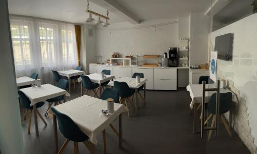 ein Restaurant mit Tischen und Stühlen und eine Küche in der Unterkunft Hotel Bartenwetzer vormals Ellenberger in Melsungen