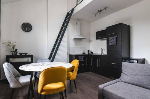 a living room with a table and chairs and a kitchen at Les Figuiers - Appartement de Standing avec 2 Chambres in Andenne
