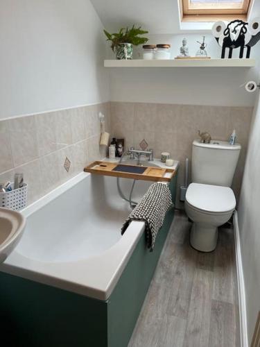 a bathroom with a tub and a toilet and a sink at Cosy & Calm Escape by the Sea in Lytham St Annes