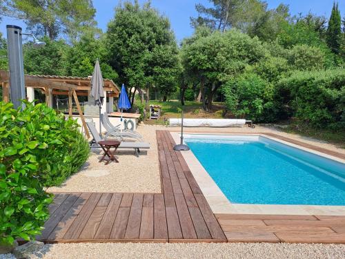a swimming pool with a swing and a chair next to it at Cabane Eco Lodge in Tourrettes-sur-Loup