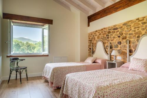 Habitación con 2 camas y ventana en Villa Colasa, casa rústica con encanto en Selaya, en Selaya