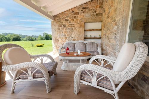 a patio with wicker chairs and a table at Villa Colasa, casa rústica con encanto en Selaya in Selaya