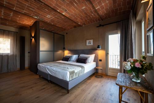 a bedroom with a bed and a brick wall at Relais Casa Clara in Montaldo Roero