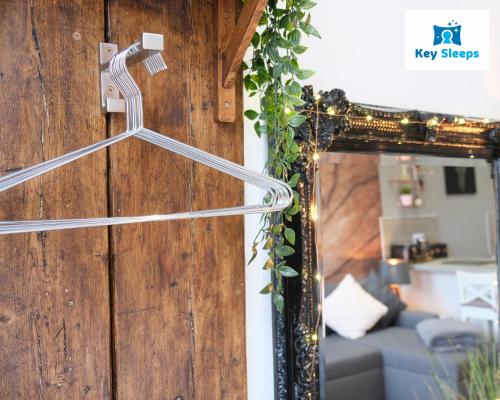 a mirror hanging on a wall next to a couch at Keysleeps Studio Apartment - Northamptonshire - Leisure & Contractors in Northampton