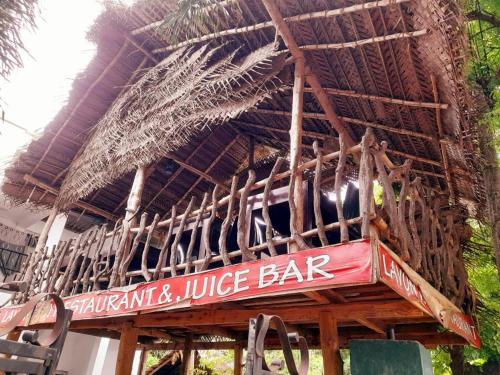 a wooden bar with a sign for a juice bar at Heritage Rangiri Villa in Dambulla