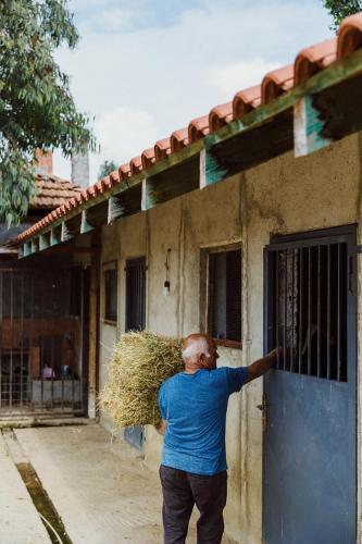 a man standing in front of a building with a door at Blerina's Agritourism Concept in Laknas