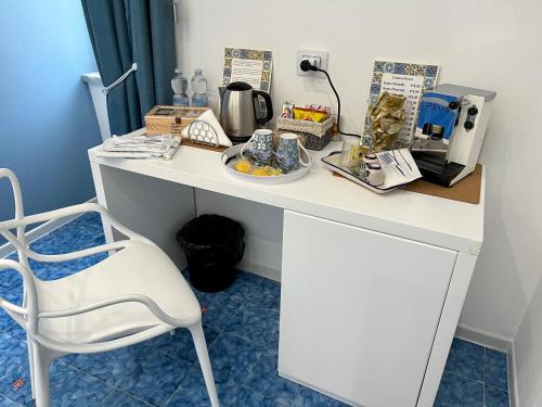 a white desk with a coffee maker and a chair at Il Sogno in Erchie