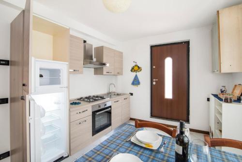 a small kitchen with a table and a refrigerator at Casa Vacanze Linda in Gera Lario
