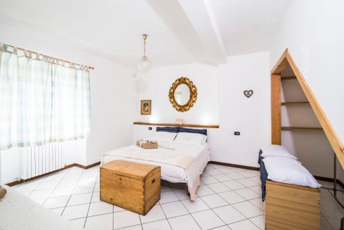 a white bedroom with a bed and a mirror at Casa Vacanze Linda in Gera Lario