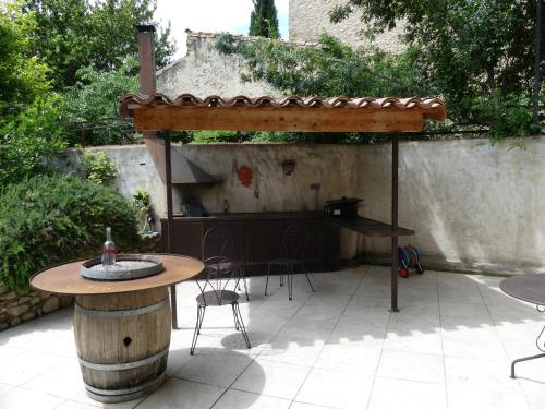 a patio with a table and an umbrella at LIMOUX RIVERSIDE GARDENs in Limoux