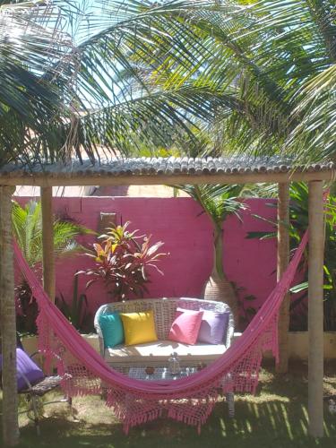 a hammock swing in a garden with palm trees at Vila Beija-flor in Canoa Quebrada