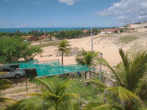 a view of a beach with a car and a building at Vila Beija-flor in Canoa Quebrada