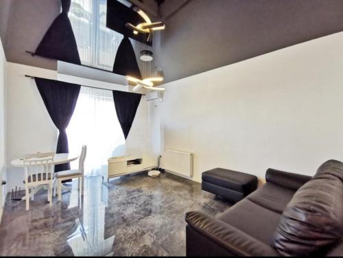 een woonkamer met een bank en een tafel bij Star Aparthotel mobilat lux cu vedere la mare si parcare in Mamaia Nord – Năvodari