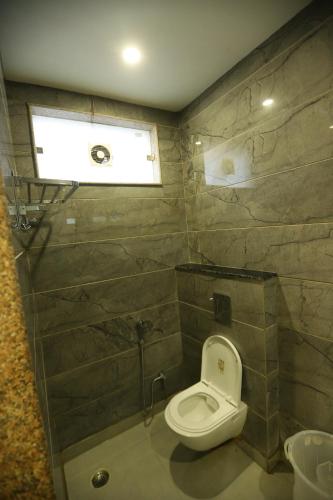 La salle de bains est pourvue de toilettes et d'une fenêtre. dans l'établissement Hotel Emporio Dx - New Delhi Railway Station - Paharganj, à New Delhi