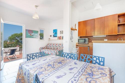 a bedroom with a bed and a kitchen with a balcony at Villetta Sant'Andrea - Goelba in SantʼAndrea