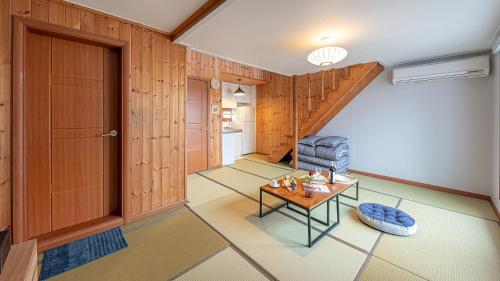 a living room with a staircase and a table at Eungabi Pension in Gangneung