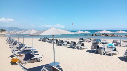 a group of chairs and umbrellas on a beach at Hotel Mercede 2 in San Felice Circeo