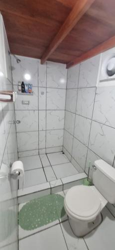 a white bathroom with a toilet and a shower at Chalet Las Cortinas in La Boquita