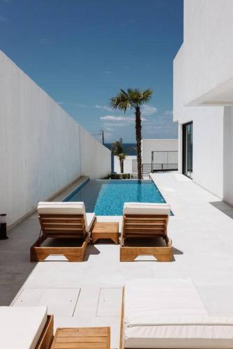 a patio with two chairs and a swimming pool at Palmera Prive Vila in Sarandë