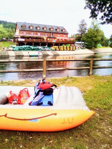 a yellow kayak sitting on the grass next to a river at Apartman LEO Nr. 8 Lipno nad Vltavou in Lipno nad Vltavou