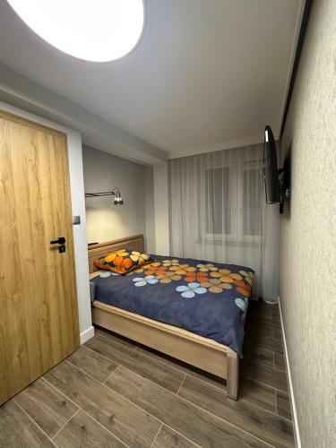 a bedroom with a bed with a blue comforter at Apartament Na Wzgórzu in Iwonicz-Zdrój