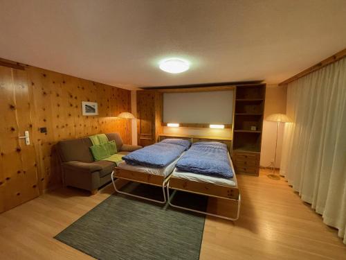 a room with a bed and a couch and a screen at Dent Blanche in Zermatt
