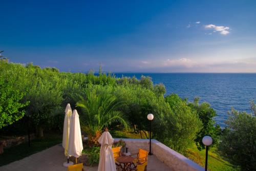 a view of the ocean from a resort with two umbrellas at Maistrali Beach Studios in Gerakini