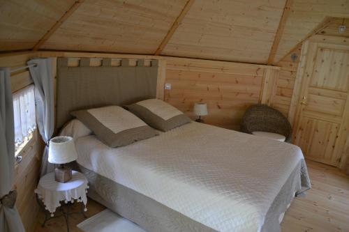 a bedroom with a bed in a wooden cabin at Le Refuge in Mornas