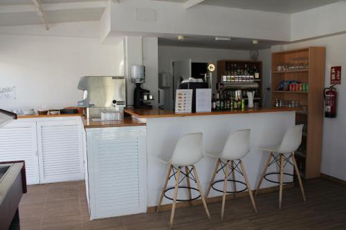 a kitchen with three stools at a counter with a bar at Canaima 307 in Puerto Rico de Gran Canaria