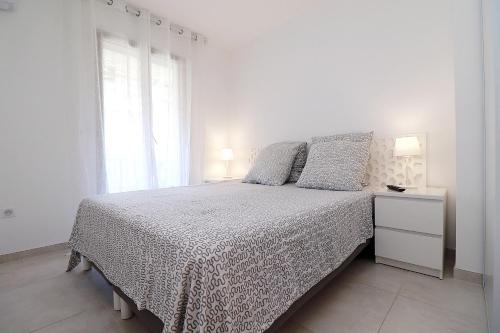 une chambre blanche avec un lit et une fenêtre dans l'établissement Magnifique 2p vue panoramique piscine grande terrasse pk, à Cannes