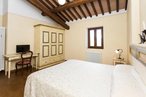 a bedroom with a white bed and a desk at Borgo Colognola - Dimora Storica in Cenerente