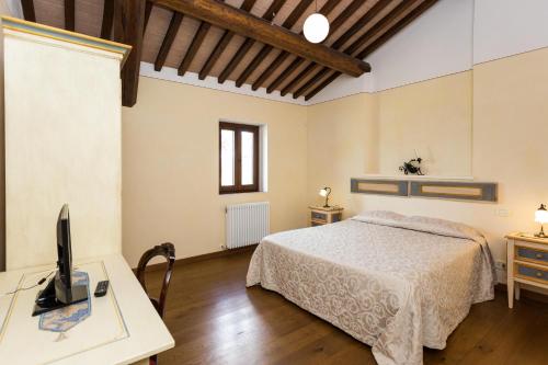 a bedroom with a bed and a desk with a computer at Borgo Colognola - Dimora Storica in Cenerente