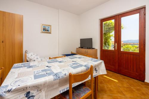 een slaapkamer met een bed, een televisie en een raam bij Agava in Novi Vinodolski