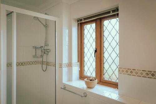 y baño con ventana, lavabo y ducha. en Wellington Quay, en Eastbourne