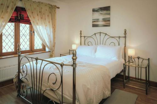1 dormitorio con 1 cama con sábanas blancas y 2 ventanas en Wellington Quay, en Eastbourne
