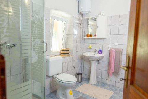 a white bathroom with a toilet and a sink at Authentic stone house Rustica near Makarska Riviera in Lovreć