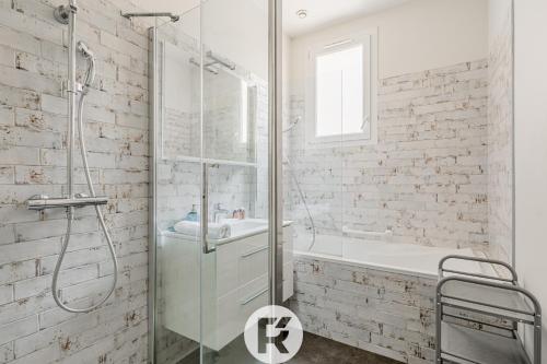 a bathroom with a glass shower and a sink at R'Apparts T3 Bastille Horizon in Grenoble