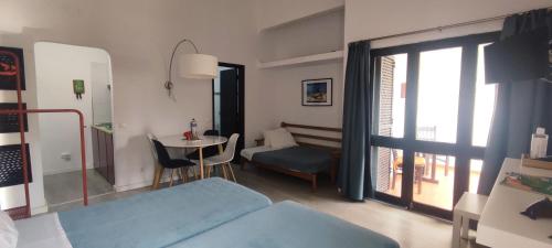 a room with a bed and a table and a window at Pedras d'el Rei - Casa Mira in Tavira