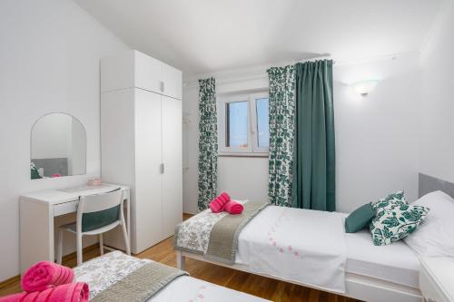 una camera con 2 letti, una scrivania e uno specchio di Apartment Rukavina a Njivice