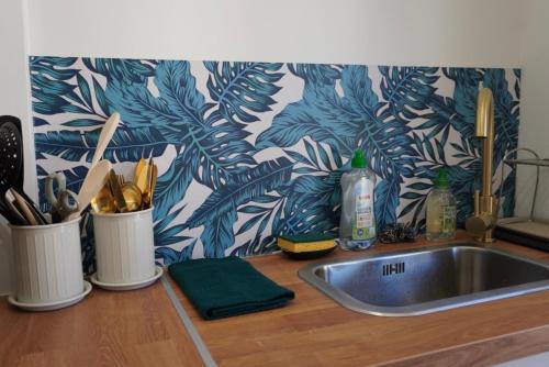 - un comptoir de cuisine avec un évier et un mur dans l'établissement Appartement en plein centre, à Avignon